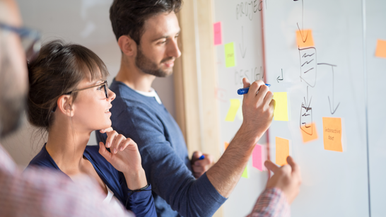 Scrum Master In A Day Kurs Personen in einem Workshop arbeiten mit Post It Wand