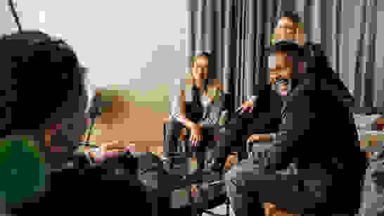 isolutions Referenzen Mitarbeitende sitzen zusammen auf einem Sofa und lachen