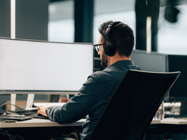 isolutions Whitepaper Cybersecurity Engineer am sitzt am Arbeitsplazt und schaut auf konzentriert in seinem Computer