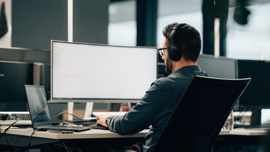 Engineer am sitzt am Arbeitsplazt und schaut auf konzentriert in seinem Computer