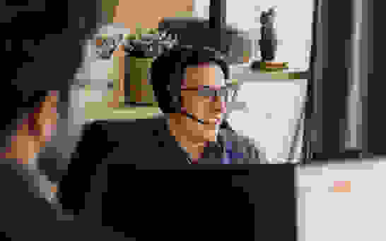 Marketing Automation - Lead Convertion Rate Mann am PC mit Headset bearbeitet Leads aus Marketing Kampagne