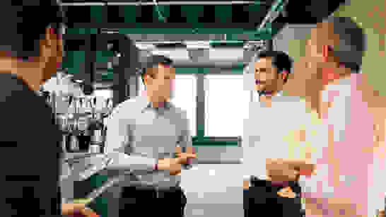 Adoption And Change Management Besprechung vor Kaffeemaschine zu Services für Adoption und Change Management