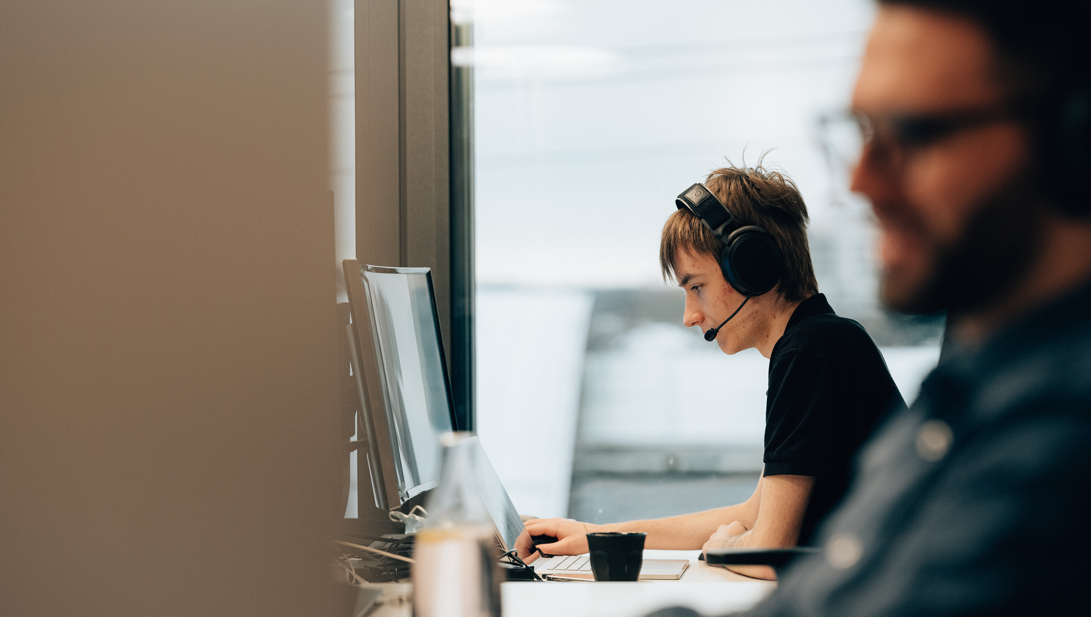 Männlicher Informatiker Plattformentwicklung arbeitet mit Headset an PC