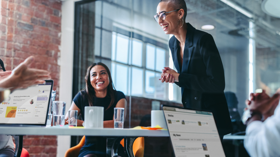 HR Bern Event Mitarbeitende stehen in einem Meeting um einen Tisch und diskutieren