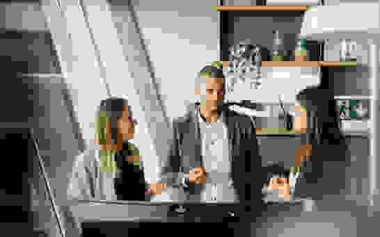 CRM Consulting - Optimizing Processes 3 Personen stehend vor Bilrschilrm besprechen Optimierung von CRM Prozesse
