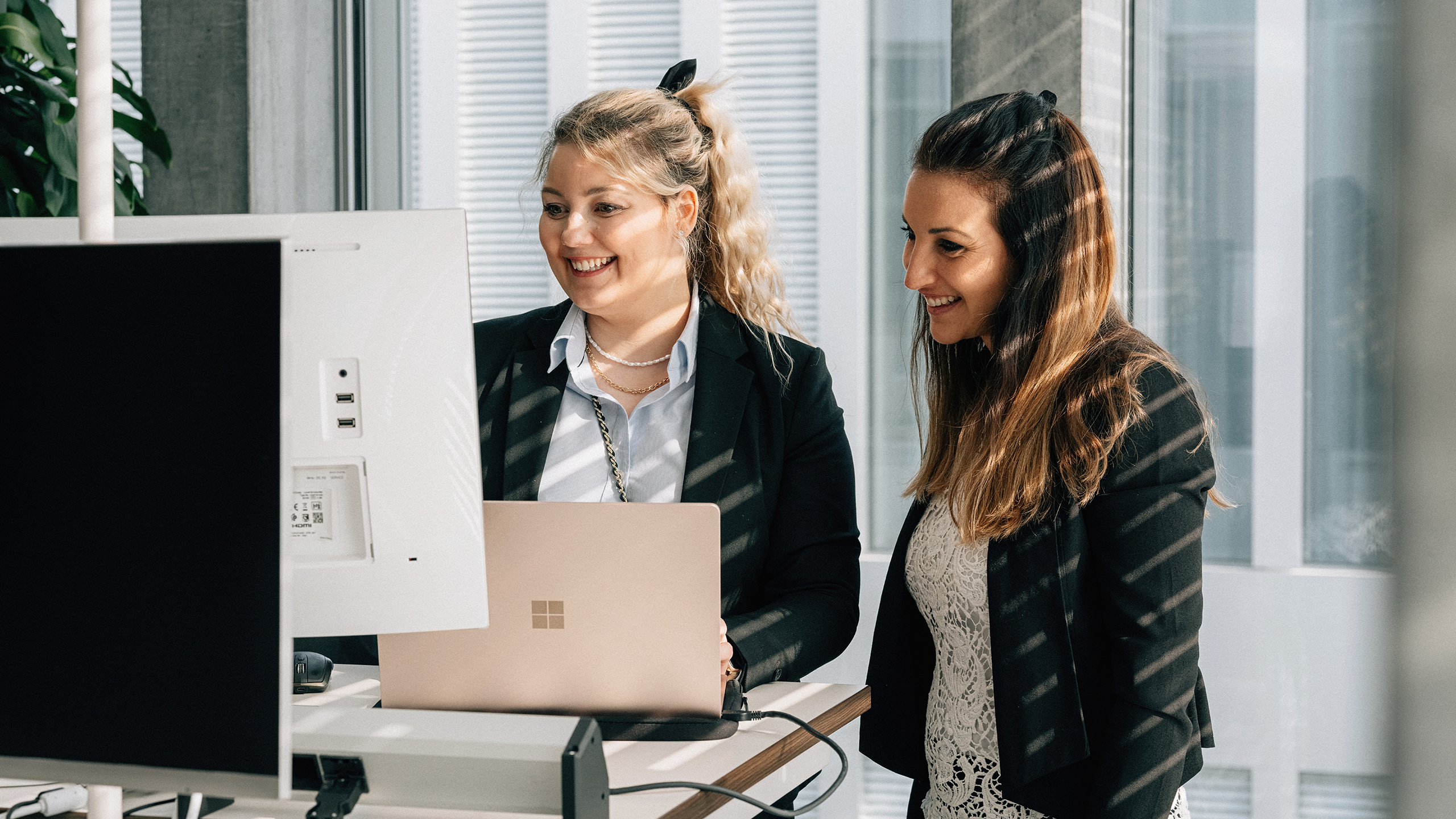 Two women standing in front of a computer