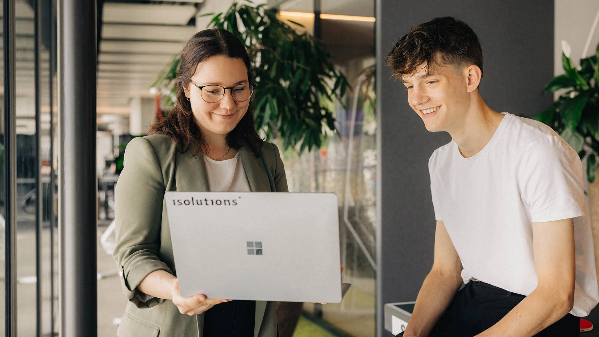 Mitarbeitende stehend am Laptop