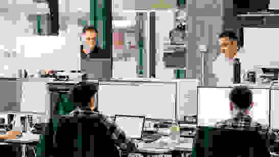 Enterprise Experts Arbeitsplatz, wo Mitarbeitende am Laptop und Screen als Enterprise Experts arbeiten