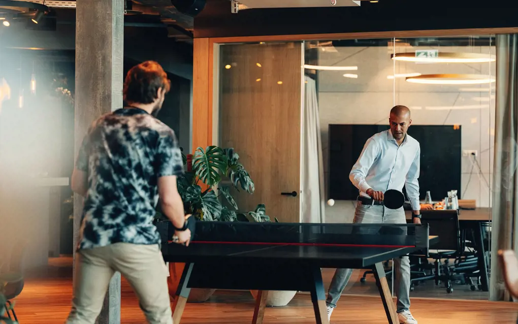Zwei Männer spielen in einem Büro Ping Pong