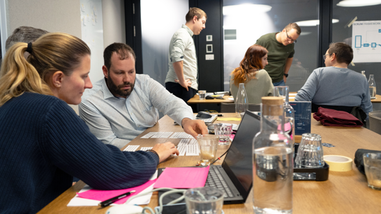 Scrum Master In A Day Workstation Workshop mit verschiedenen Stationen in einem Meetingraum