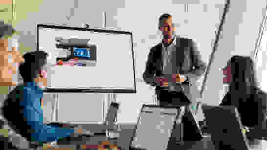 isolutions Academy Meeting mit 4 Personen am Laptop die am lachen sind