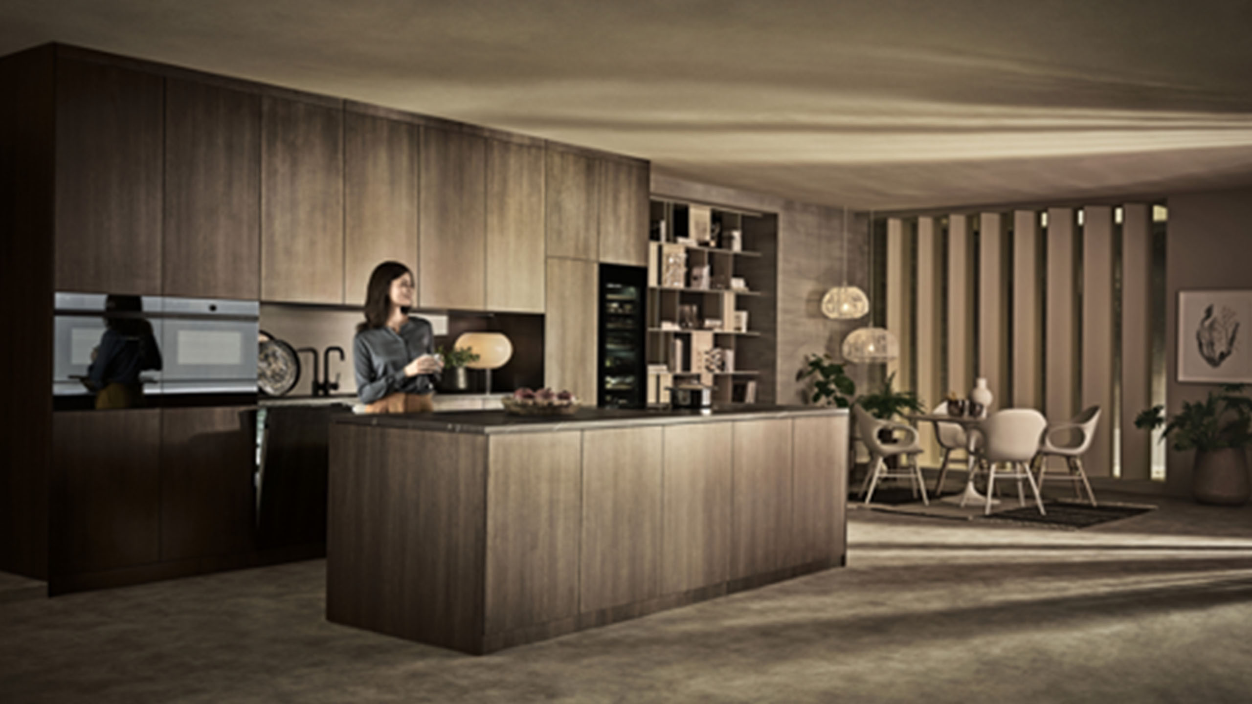 V-ZUG Küche mit Insel in braunem Holz und einer Frau in der Küche