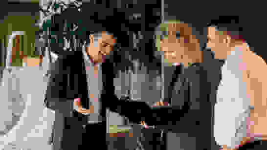 Intranet Extranet 3 Mitarbeitende stehen im Gang an einem Laptop und schauen rein