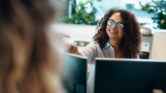 Whitepaper KI im Public Sector Dame am Schalter überreicht Kundin ein Dokument