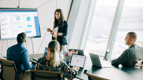 Business Relevanz Marketing Sitzung mit 4 Personen mit Kennzahlen auf dem Screen
