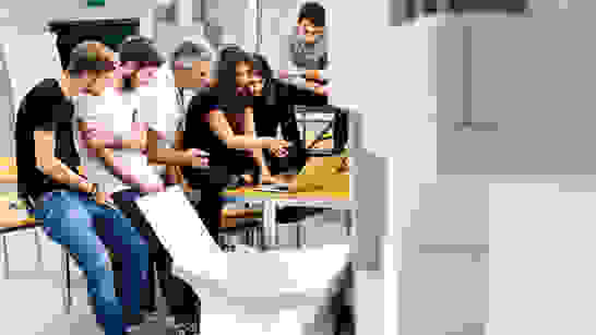 ZHAW Microsoft Dynamics 365 Studierende sitzen zusammen, schauen in Laptop und besprechen etwas