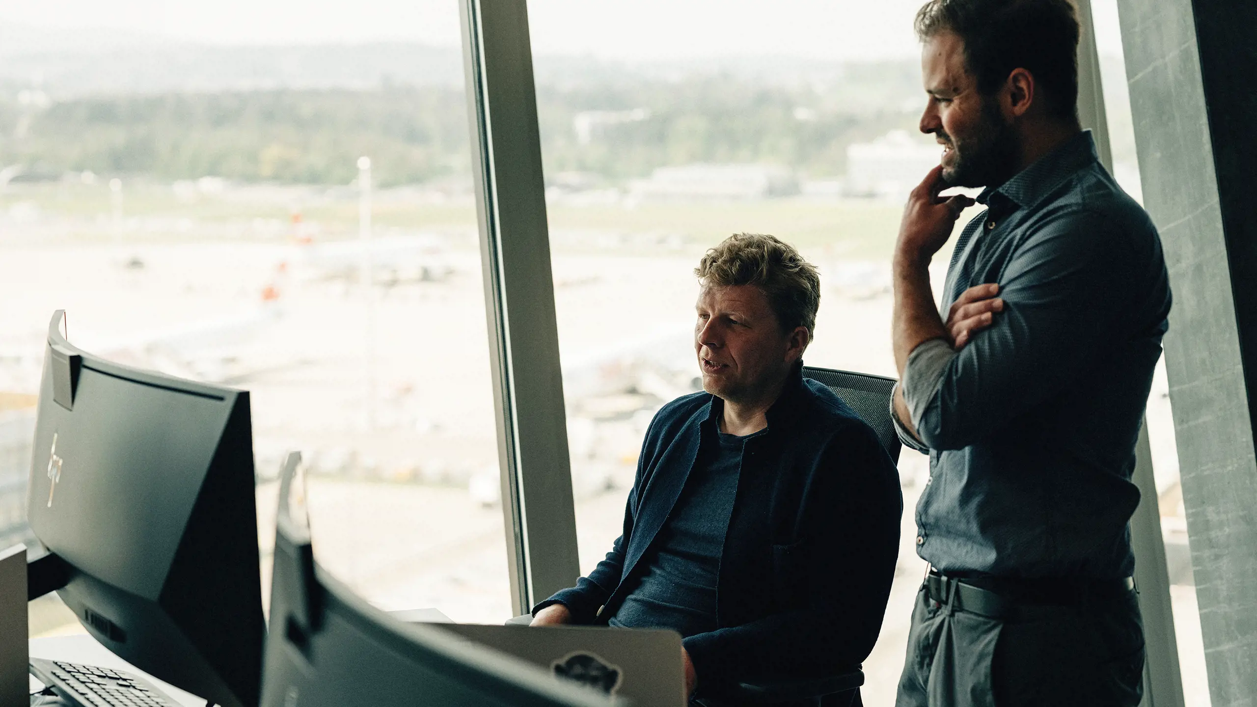 Zwei Herren diskutieren in einem Büro vor dem Computer