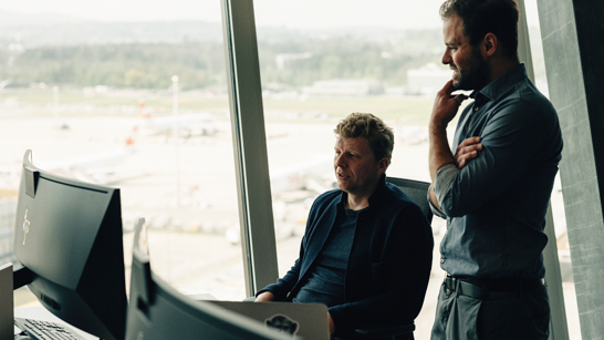 Künstliche Intelligenz Zwei Herren diskutieren in einem Büro vor dem Computer