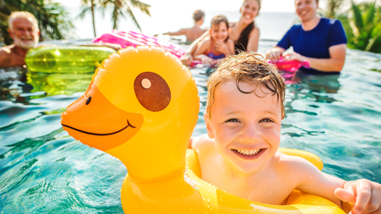 Family in Pool mit Kinder am Sommeruralub geniessen