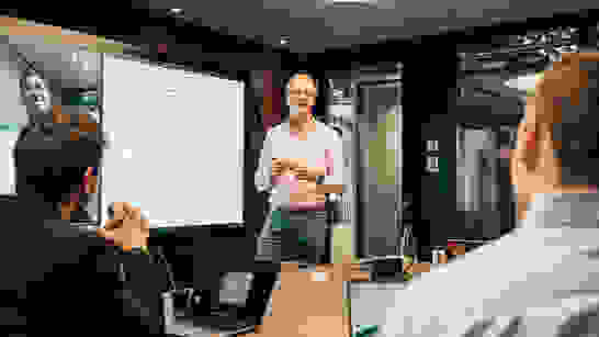 Security Services Hybrid Meeting mit SurfaceHub, wo Security Services am Whiteboard skizziert sind