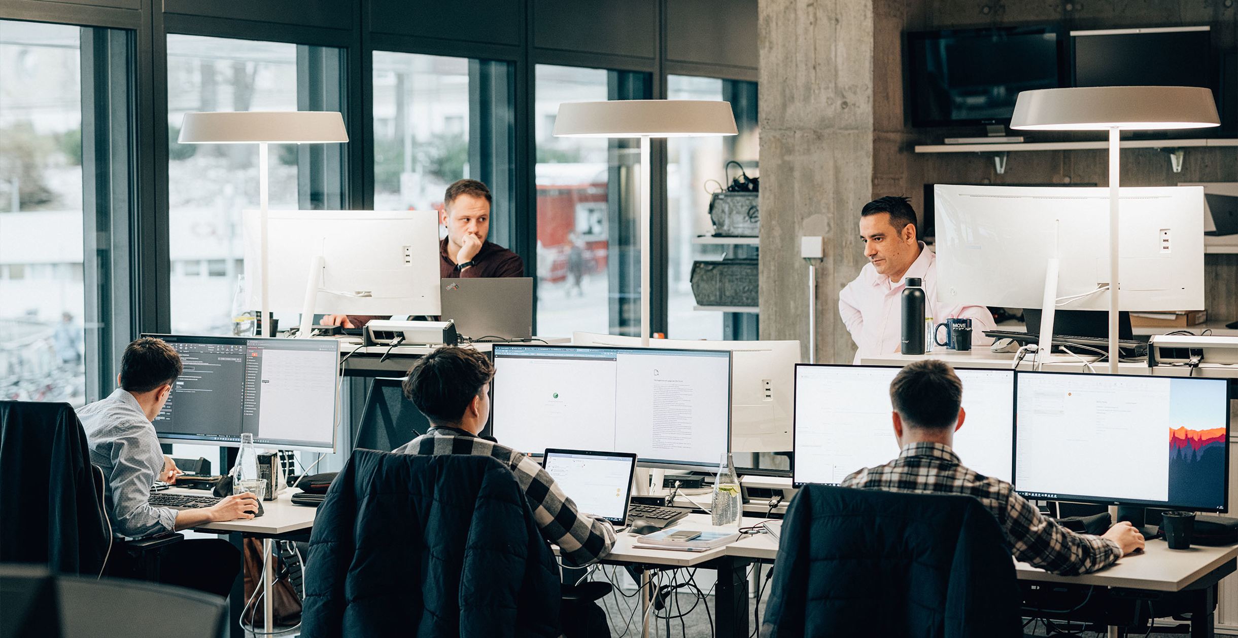 Arbeitsplatz, wo Mitarbeitende am Laptop und Screen als Enterprise Experts arbeiten
