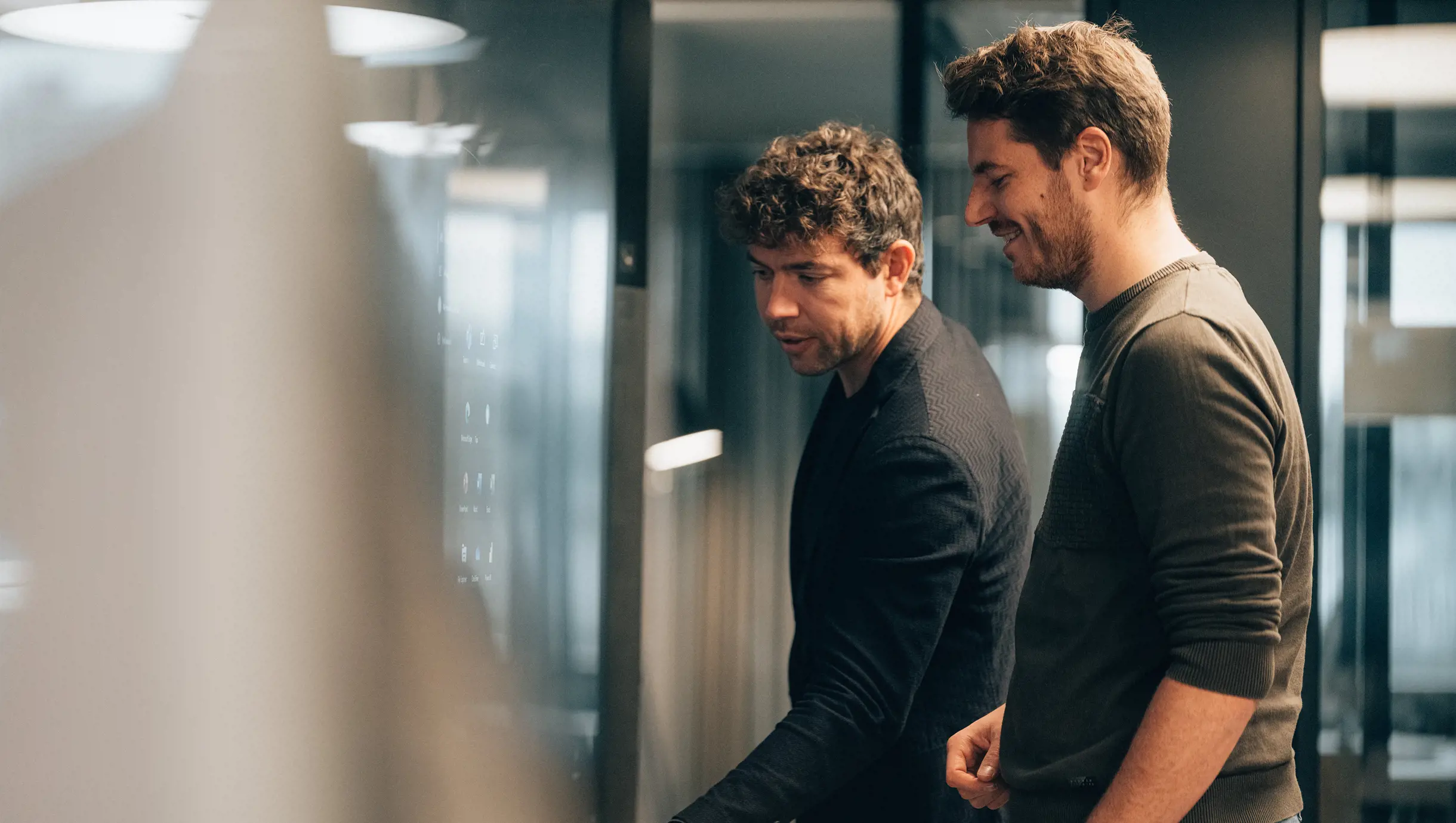 Männlicher Lead M365 Cloud Engineer Operations steht  mit Mann vor Surfacehub