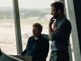 Zwei Männer tauschen sich am Arbeitsplatz aus und schauen dabei in ein Screen