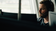Offene Stelle bei isolutions als Informatiker EFZ Applikationsentwicklung Männlicher Informatiker in Applikationsentwicklung sitzt mit Headset vor PC Bildschirm