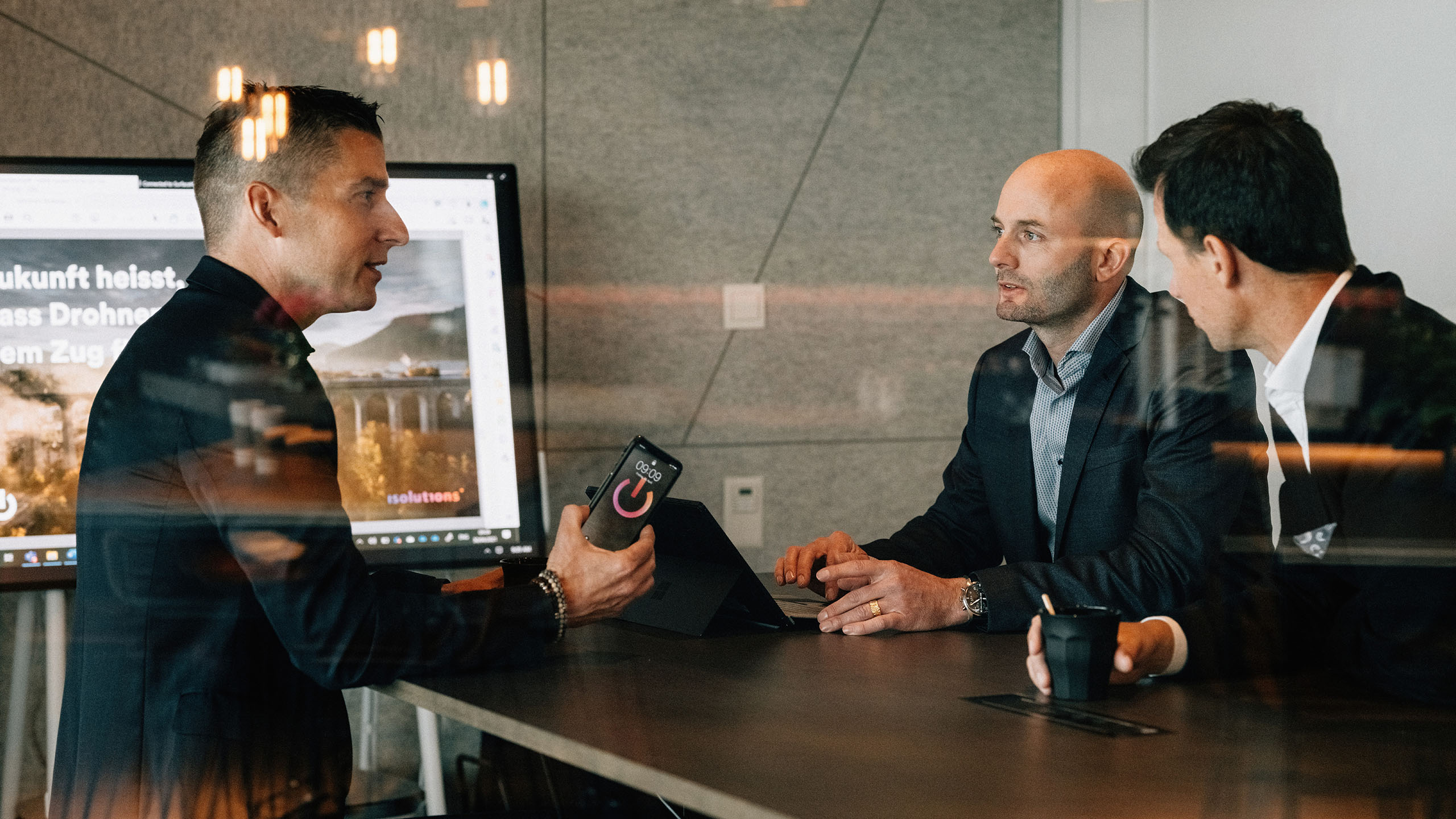 3 Herren besprechen in Sitzungzimmer Optimierung und Beratung von CRM