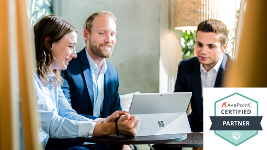 Avepoint isolutions Certified Partner Header 3 Personen Sitzen in einer Lounge um einen Microsoft Surfe PC