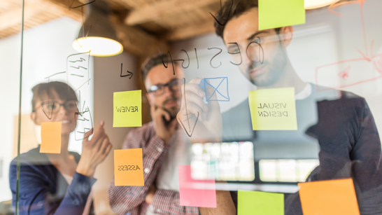 Scrum Master In A Day Personen in einem Workshop arbeiten mit Post It Wand