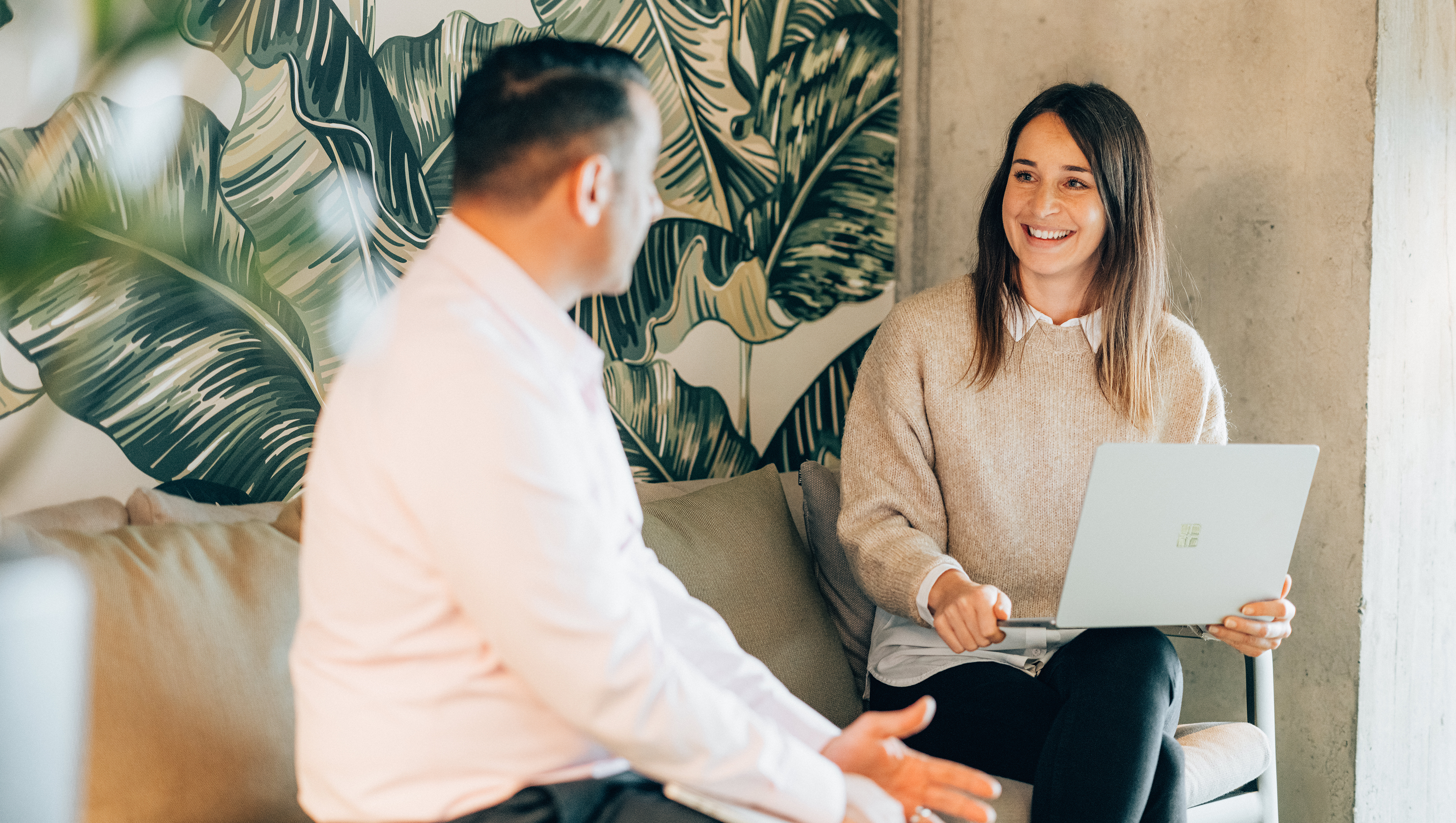 Männlicher Azure Cloud Engineer spricht mit Frau auf Sofa 