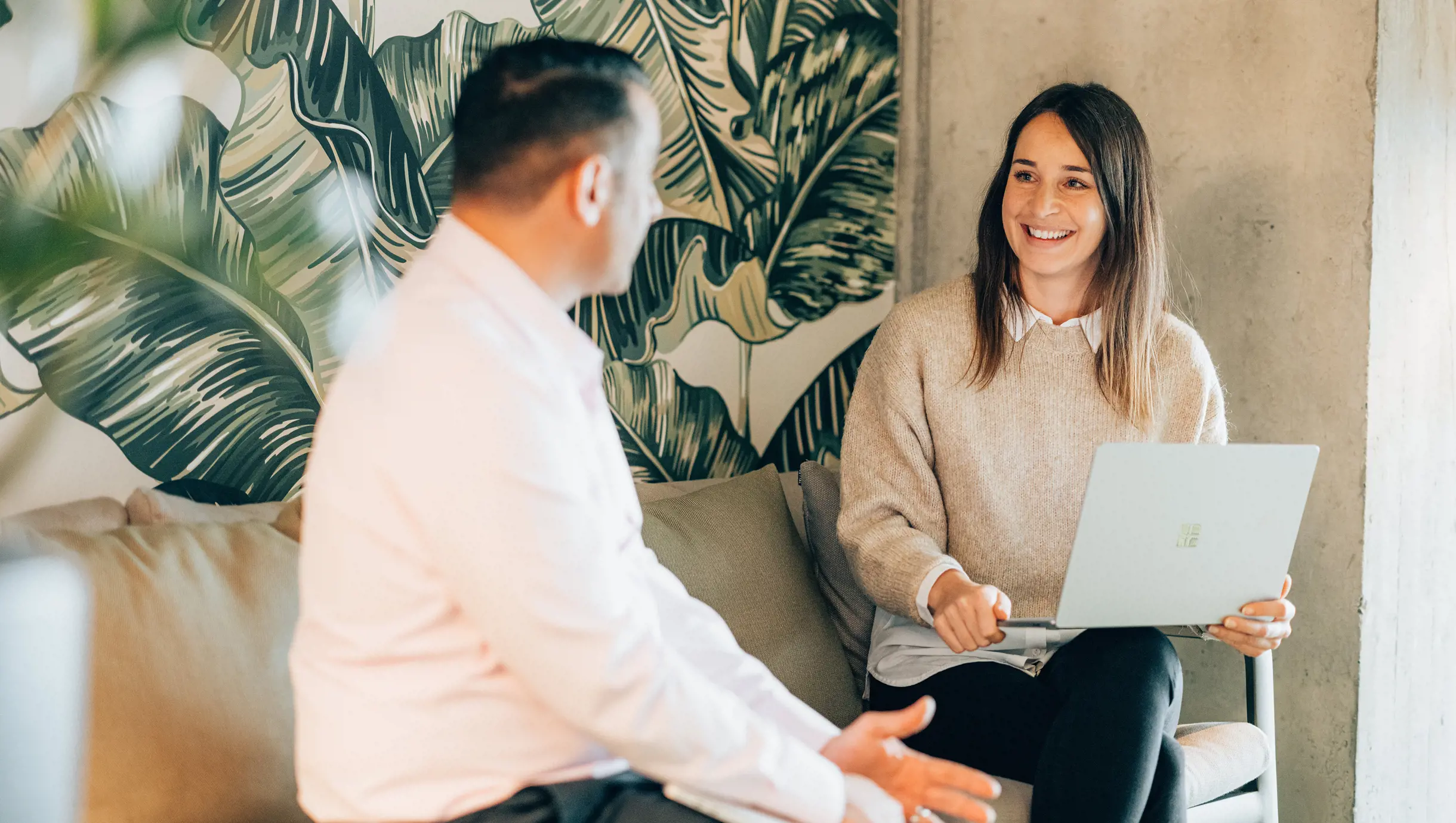 Männlicher Azure Cloud Engineer spricht mit Frau auf Sofa 