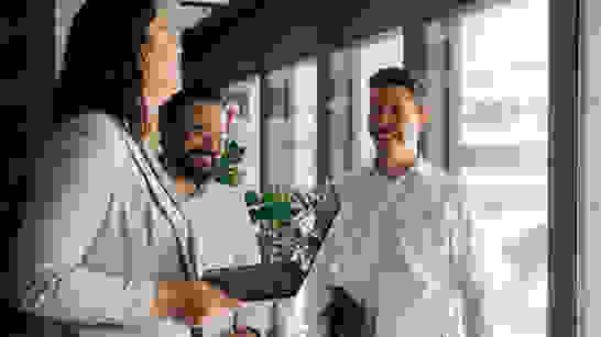isolutions Team Drei Personen im Gang lachen sich gegenseitig an