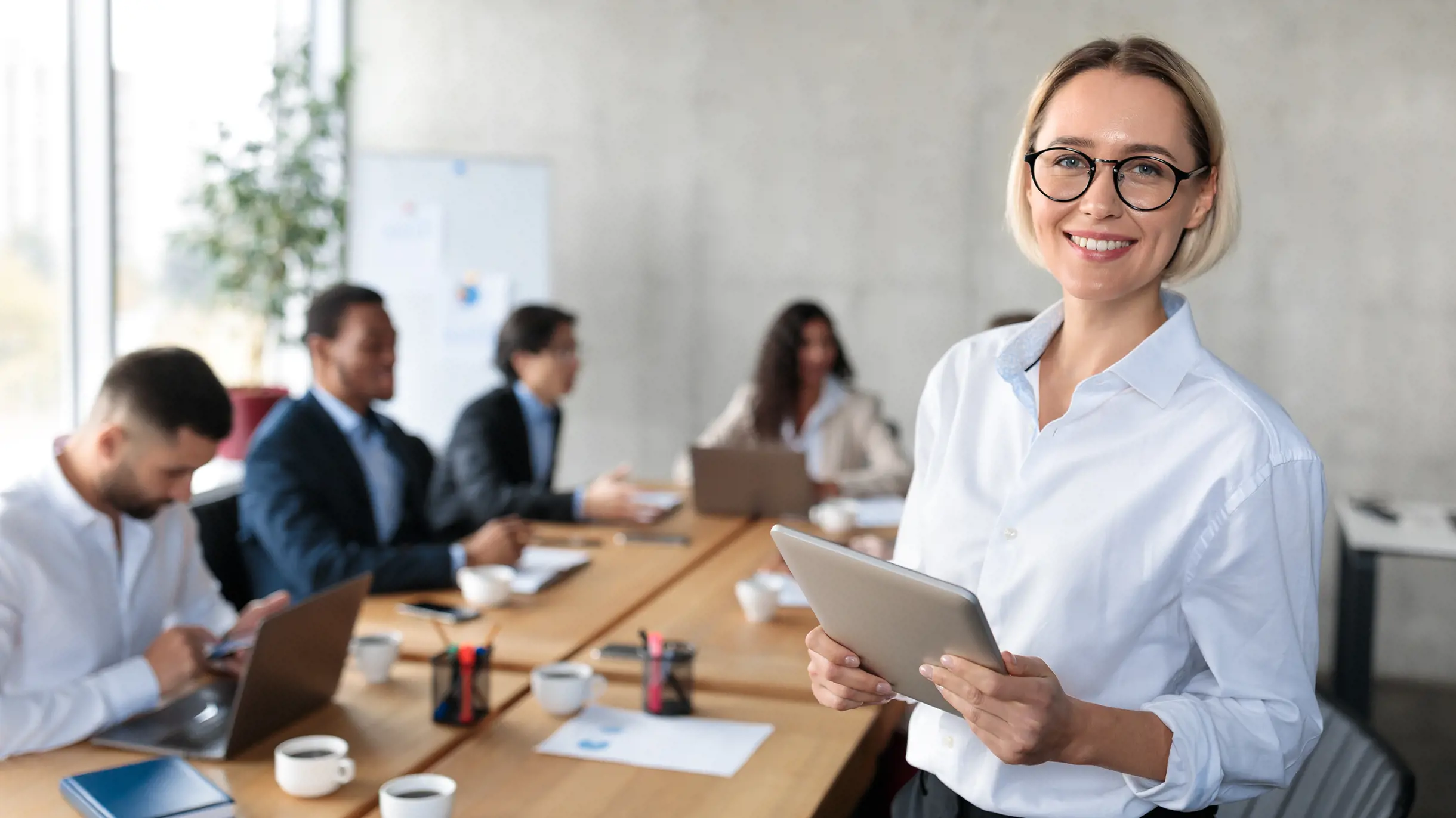 Business Frau mit weissem Hemd hält ein Tablet