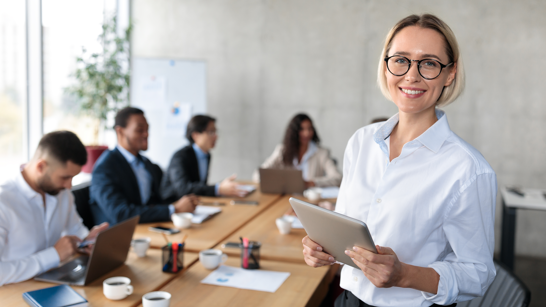 Business Frau mit weissem Hemd hält ein Tablet