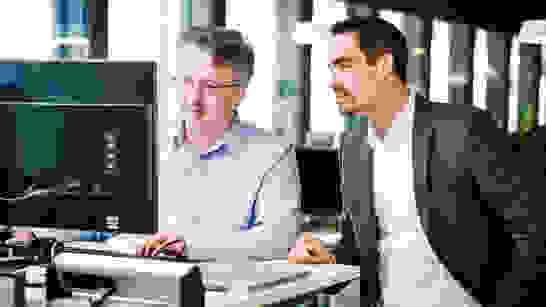 2 Personen vor dem PC zur Besprechung von Application Modernization