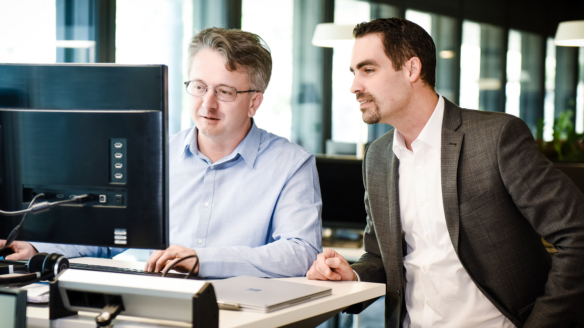 2 Personen vor dem PC zur Besprechung von Application Modernization