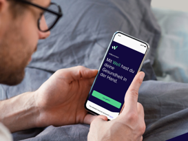 Well Case Study mit isolutions Mann schaut auf das Handy mit der offenen Well Gesundheits-App