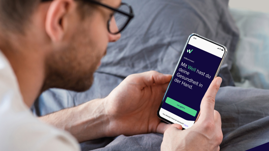 Well Case Study mit isolutions Mann schaut auf das Handy mit der offenen Well Gesundheits-App