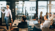 Offene Stelle bei isolutions als Senior Project Manager Männlicher Senior Project Manager steht in Sitzungszimmer vor Surfacehub und zeichnet