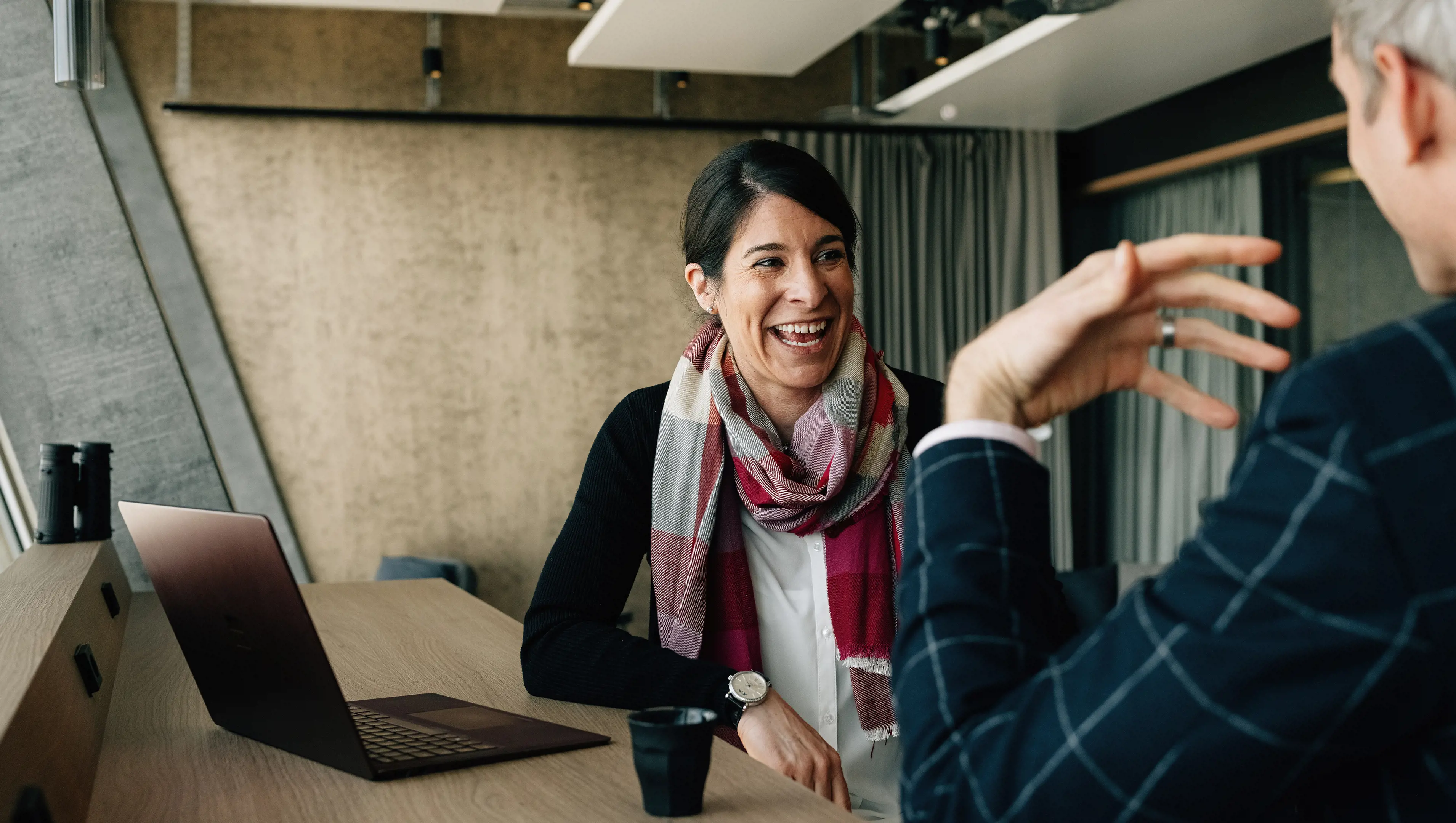 Weibliche Chief HR Officer sitzt mit Mann zusammen und lacht