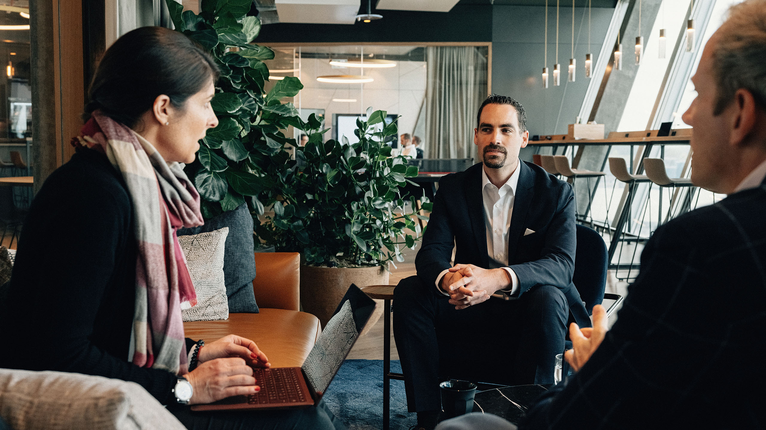 3 Personen in Lounge besprechen das isolutions Angebot zu Business Solutions