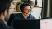 Offene Stelle bei isolutions als Technical Consultant M365 Digital Workplace Männlicher Technical Consultant sitzt mit Headset vor PC Bildschirm
