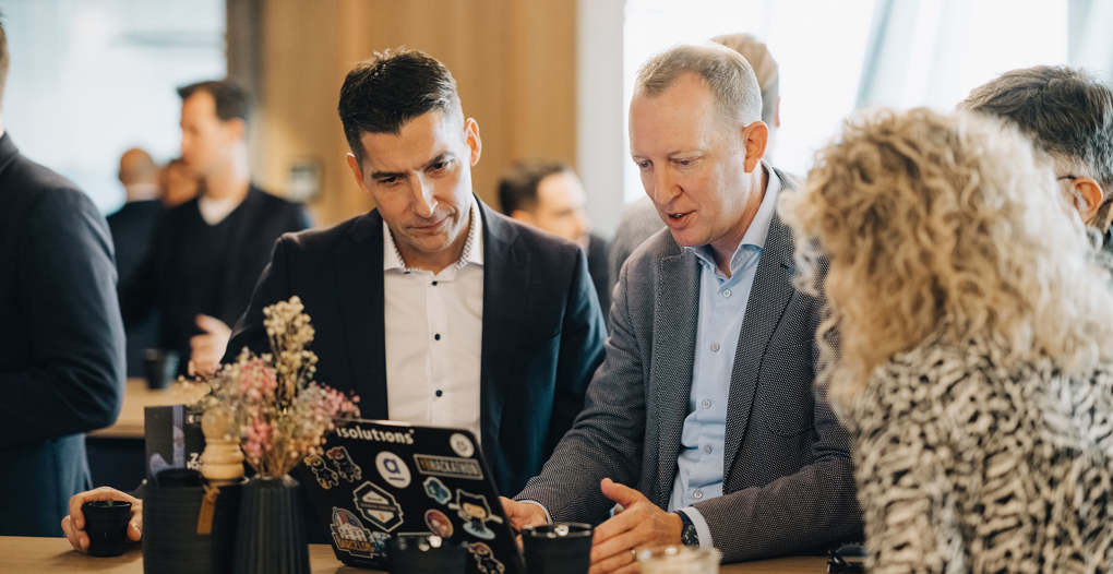 4 Personen an einem Event schauen in PC und visualisieren Digital Sales Prozess