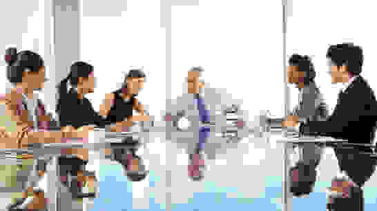 VZPM Workplace as a Service Menschen in einer Sitzung am Glastisch, das alle spiegelt