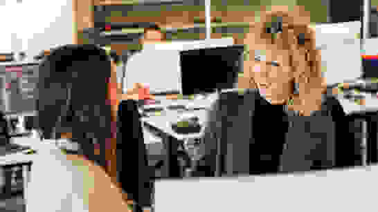 Customer Services 2 Frauen vor PC, eine am Lachen, besprechen Angebote für Customer Services