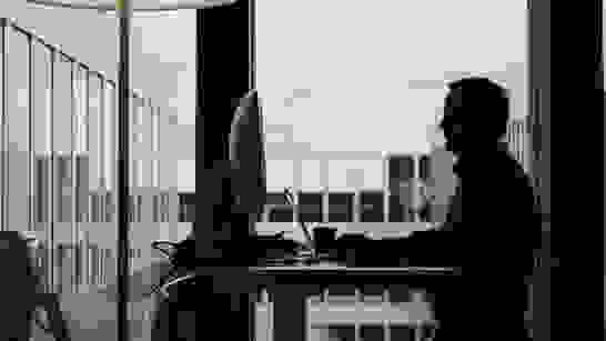 isolutions AGB Mann von der Seite am Arbeitsplatz mit Aussicht