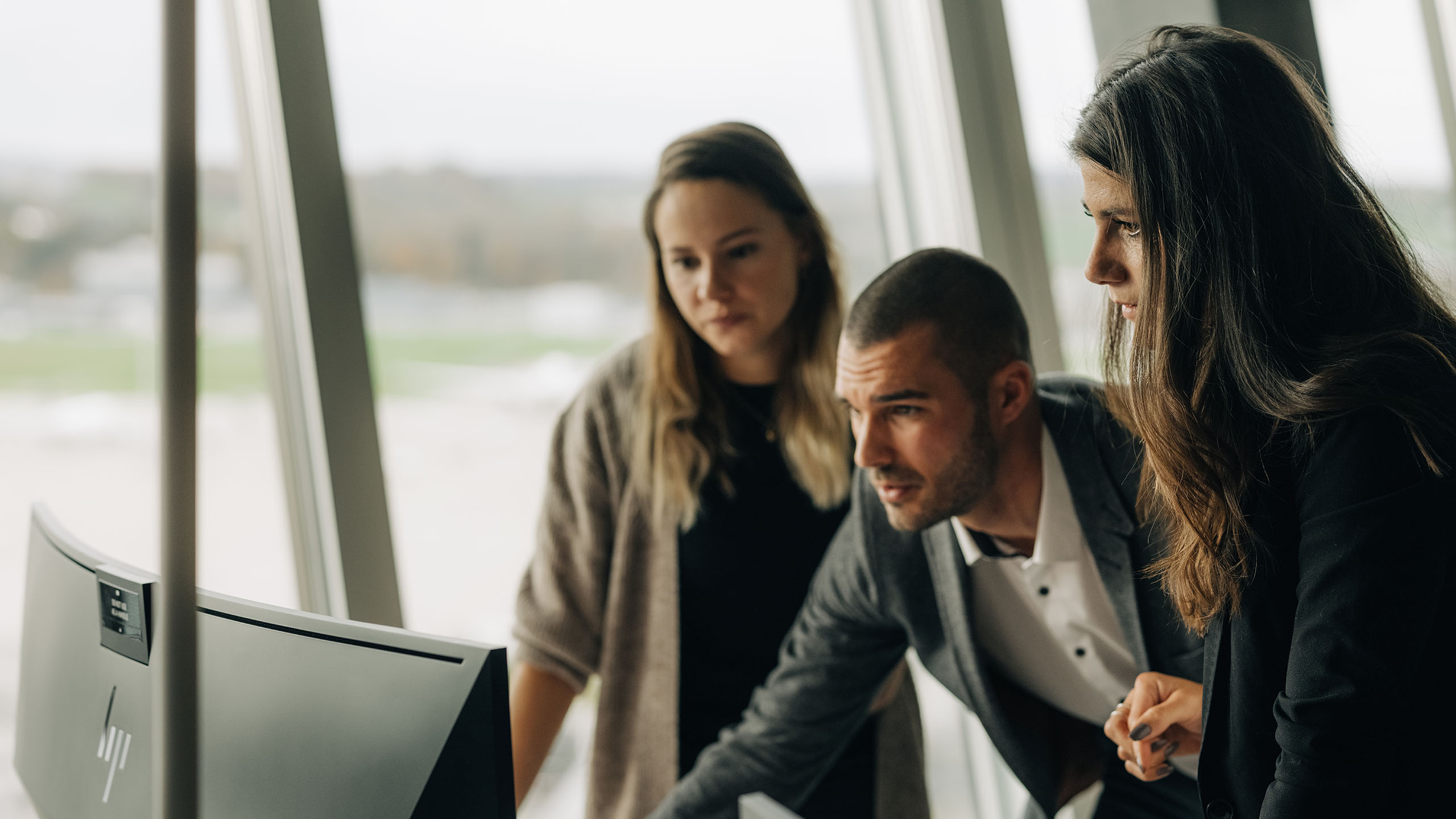 3 junge Menschen schauen in Computer und bauen Marketing Automation auf
