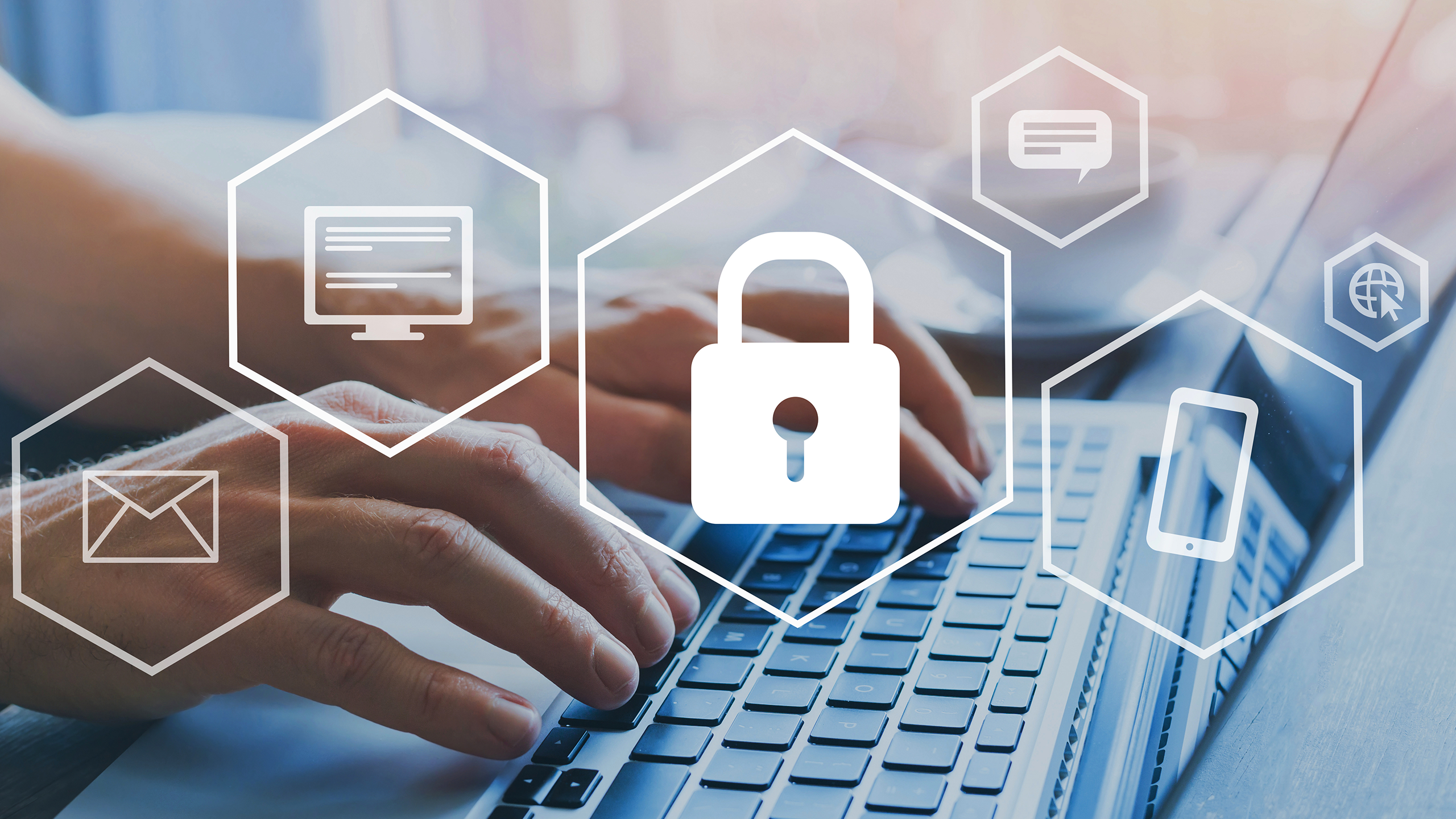 Hände die auf Tastatur eines Laptops tippen mit Icons von Sicherheit im Vordergrund
